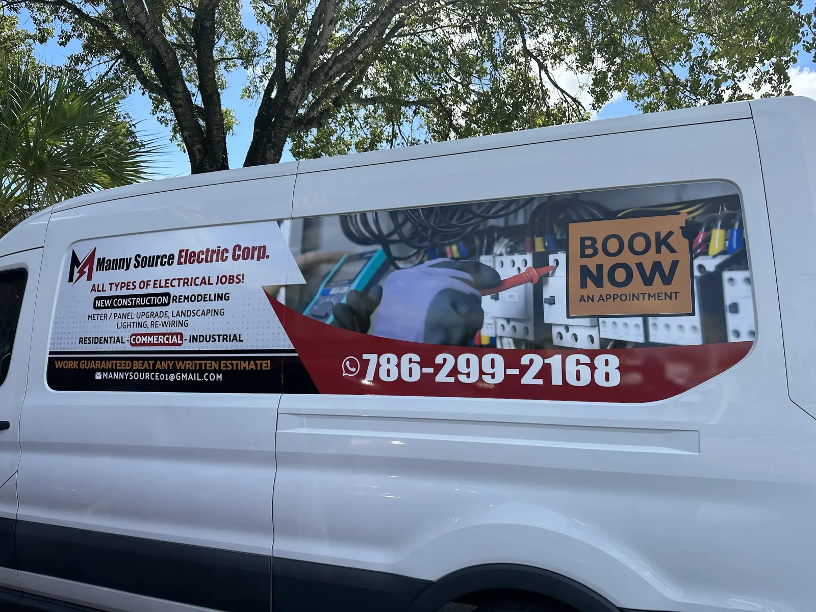 The Manny Source Electric van with its lettering in Spanish and English
